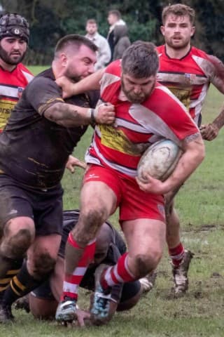 Sam playing rugby, carrying the ball in a match